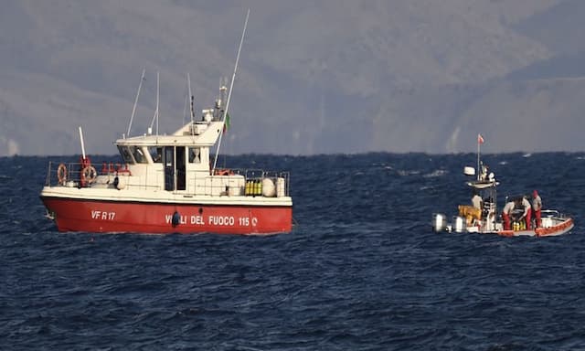 Rescue crews unload body bag in Sicily port as search continues after yacht sinking - https://cdn.connectfm.ca/Rescue-crews.jpg